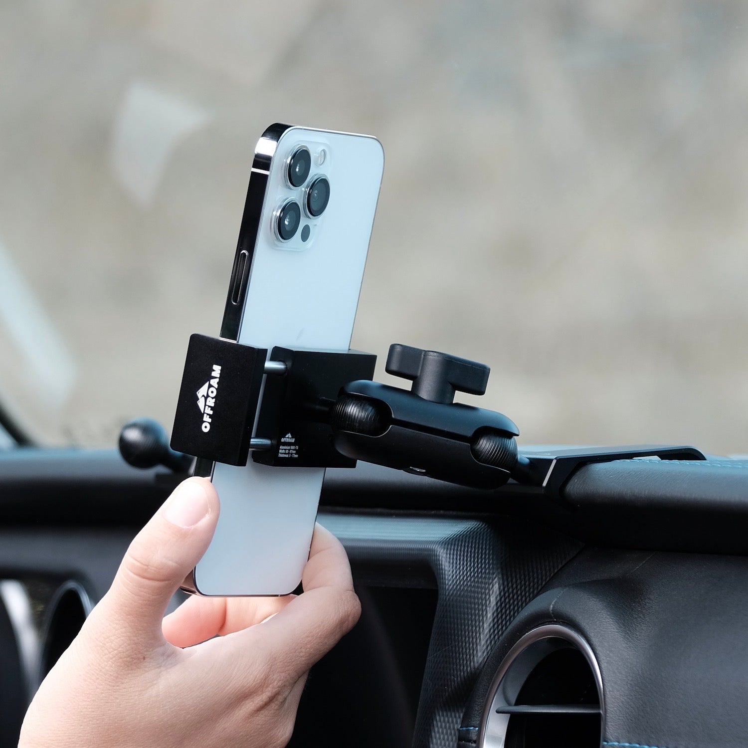 Image of Offroam Phone Mount installed securely in Jeep Wrangler 2018-2023 | Gladiator 2019-2023. This premium phone mount installs easily without drilling or glue. Spring loaded Universal holder for use with any phone. Perfect placement without blocking screens, driver view, or air flow. Fully adjustable positioning.