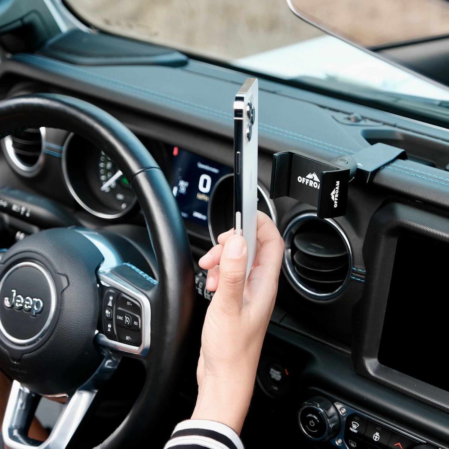 Image of Offroam Phone Mount installed securely in Jeep Wrangler 2018-2023 | Gladiator 2019-2023. This premium phone mount installs easily without drilling or glue. Spring loaded Universal holder for use with any phone. Perfect placement without blocking screens, driver view, or air flow. Fully adjustable positioning.
