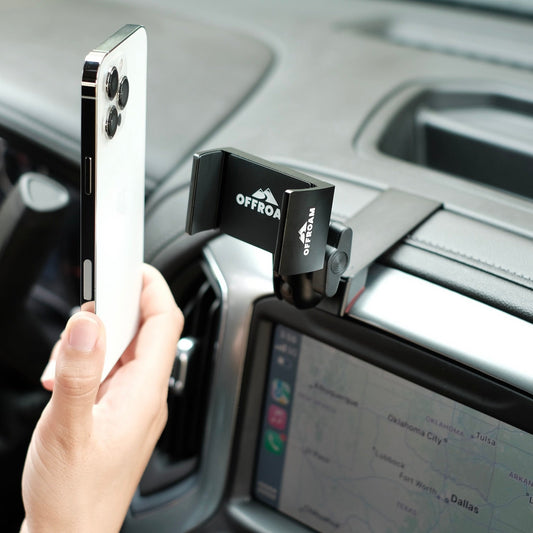 Image of Offroam Phone Mount installed securely in Chevrolet Silverado 2019-2024 | Silverado HD 2020-2024 and GMC Sierra 1500 2019-2021 | Sierra HD 2020-2023 with 7-in.|8-in. display. This premium phone mount installs easily without drilling or glue. Spring loaded Universal holder for use with any phone. Perfect placement without blocking screens, driver view, or air flow. Fully adjustable positioning.