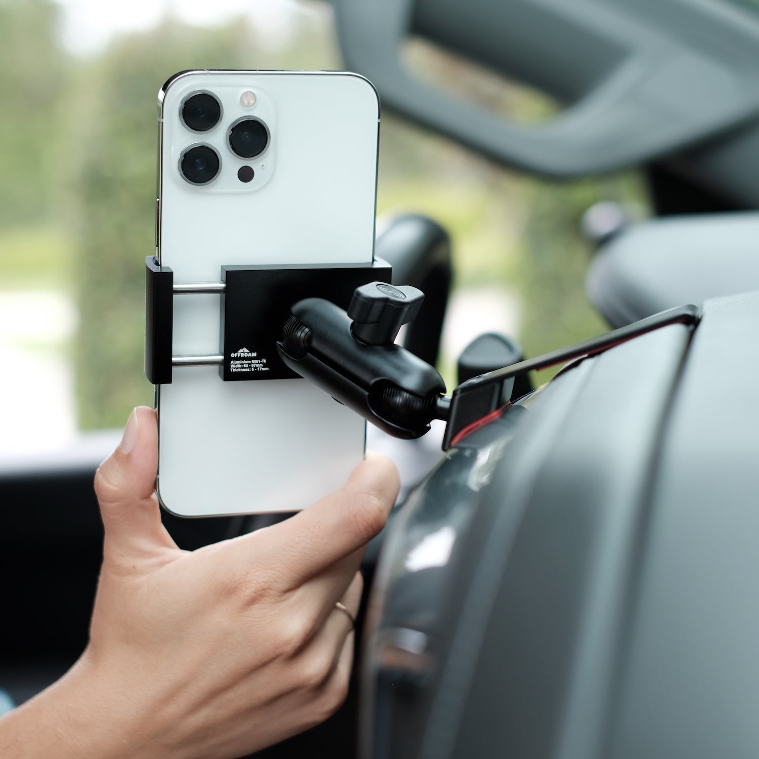 Image of Offroam Phone Mount installed securely in Chevrolet Silverado 2019-2024 | Silverado HD 2020-2024 and GMC Sierra 1500 2019-2021 | Sierra HD 2020-2023 with 7-in.|8-in. display. This premium phone mount installs easily without drilling or glue. Spring loaded Universal holder for use with any phone. Perfect placement without blocking screens, driver view, or air flow. Fully adjustable positioning.