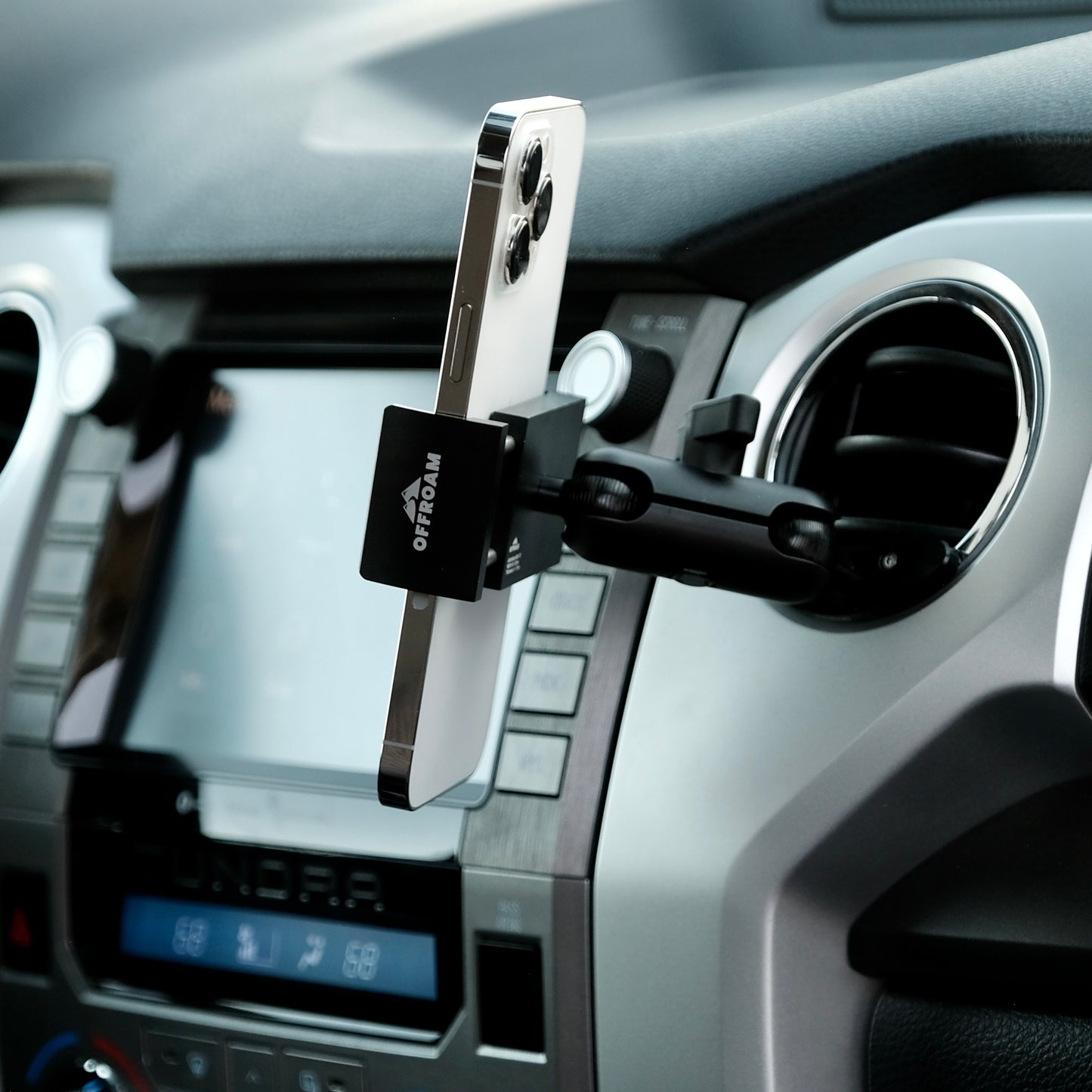 Image of Offroam Phone Mount installed securely in Toyota Tacoma 2016-2023 | Tundra 2014-2021. This premium phone mount installs easily without drilling or glue. Spring loaded Universal holder for use with any phone. Perfect placement without blocking screens, driver view, or air flow. Fully adjustable positioning.