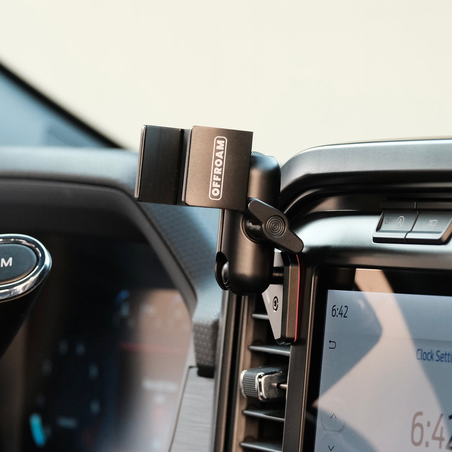 Image of Offroam Phone Mount installed securely in Ford F-150 2021-2025 | F-250/F-350 2023-2025 | F-150 Lightning (XL & PRO) 2022-2025. This premium phone mount installs easily without drilling or glue. Spring loaded Universal holder for use with any phone. Perfect placement without blocking screens, driver view, or air flow. Fully adjustable positioning.
