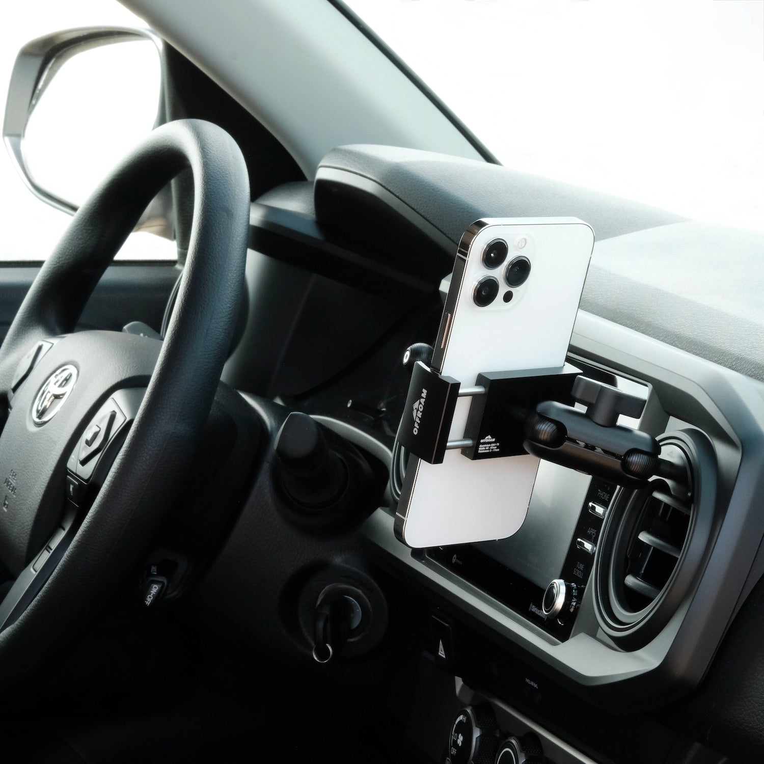 Image of Offroam Phone Mount installed securely in Toyota Tacoma 2016-2023 | Tundra 2014-2021. This premium phone mount installs easily without drilling or glue. Spring loaded Universal holder for use with any phone. Perfect placement without blocking screens, driver view, or air flow. Fully adjustable positioning.