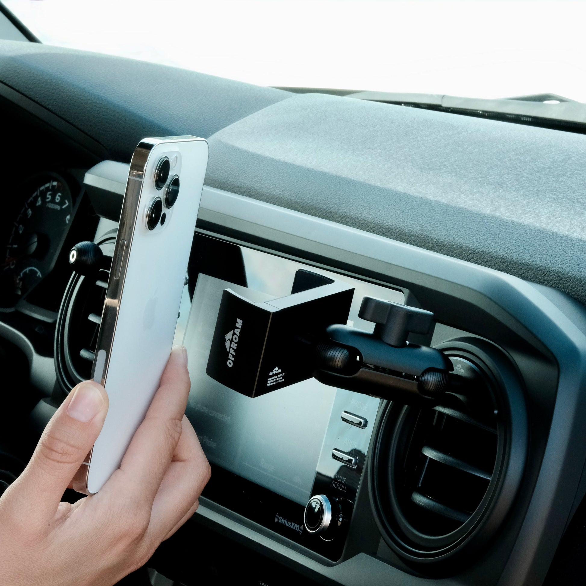 Image of Offroam Phone Mount installed securely in Toyota Tacoma 2016-2023 | Tundra 2014-2021. This premium phone mount installs easily without drilling or glue. Spring loaded Universal holder for use with any phone. Perfect placement without blocking screens, driver view, or air flow. Fully adjustable positioning.
