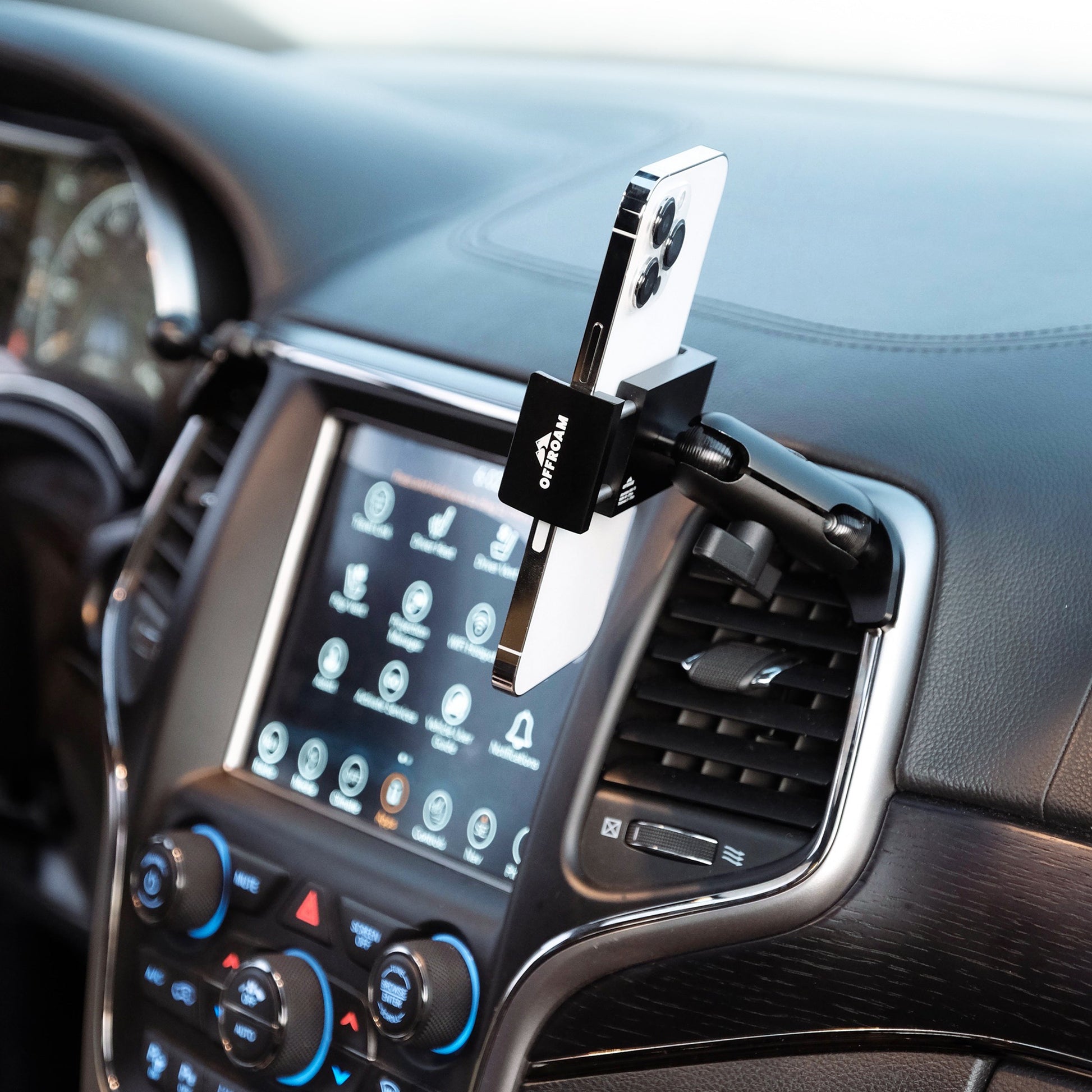 Image of Offroam Phone Mount installed securely in Jeep Grand Cherokee WK2 2014-2022. This premium phone mount installs easily without drilling or glue. Spring loaded Universal holder for use with any phone. Perfect placement without blocking screens, driver view, or air flow. Fully adjustable positioning.