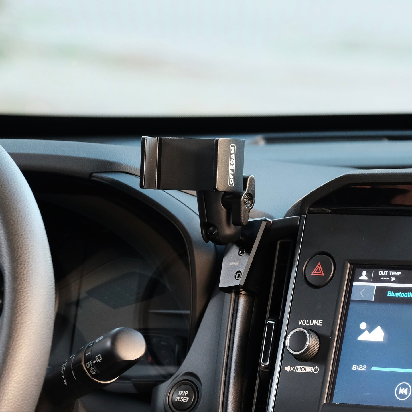 Image of Offroam Phone Mount installed securely in Subaru Forester 2025-2026. This premium phone mount installs easily without drilling or glue. Spring loaded Universal holder for use with any phone. Perfect placement without blocking screens, driver view, or air flow. Fully adjustable positioning.