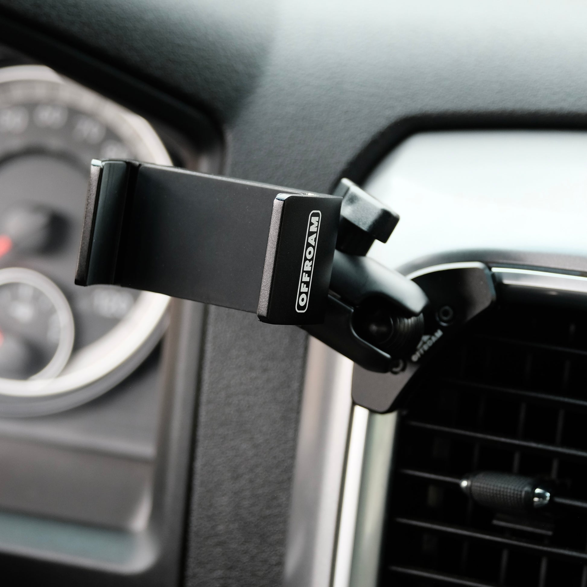 Image of Offroam Phone Mount installed securely in Ram 1500/2500/3500 2013-2018 & Ram Classic 2019-2024. This premium phone mount installs easily without drilling or glue. Spring loaded Universal holder for use with any phone. Perfect placement without blocking screens, driver view, or air flow. Fully adjustable positioning.