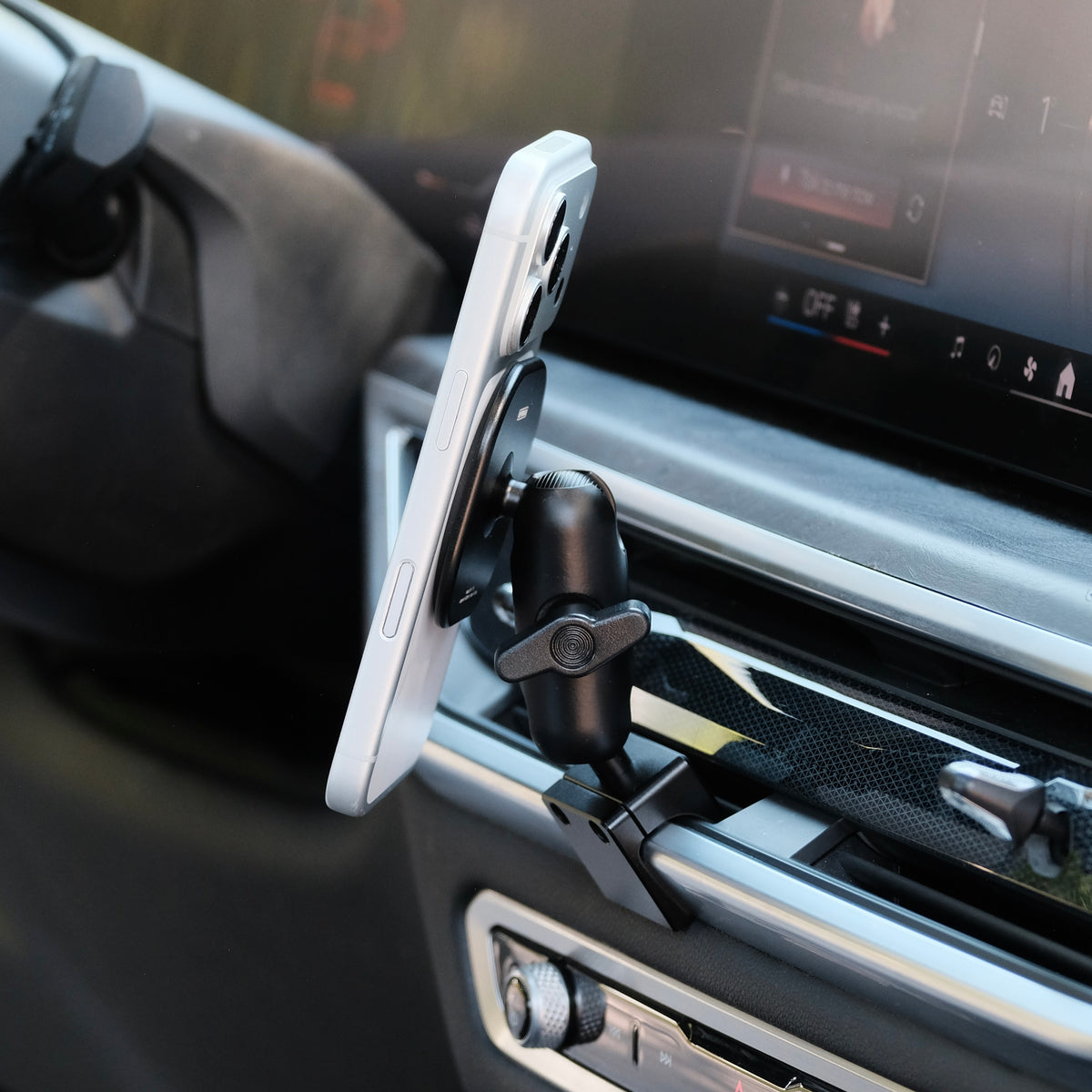 Image of Offroam MagSafe-compatible Phone Mount installed securely in BMW X5 2024-2026 | X6 2024-2027 | X7 2023-2027. This premium phone mount installs easily without drilling or glue. High force magnets hold phone on any trail, road, or track. Perfect placement without blocking screens, driver view, or air flow. Fully adjustable positioning.