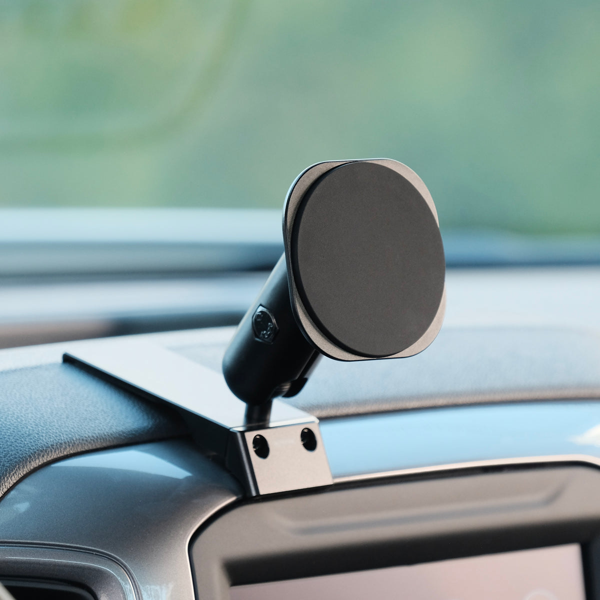 Image of Offroam MagSafe-compatible Phone Mount installed securely in Chevrolet Silverado 2019-2026 | Silverado HD 2020-2026 & GMC Sierra 1500 2019-2026 | Sierra HD 2020-2026 with 7-in.|8-in. display. This premium phone mount installs easily without drilling or glue. High force magnets hold phone on any trail, road, or track. Perfect placement without blocking screens, driver view, or air flow. Fully adjustable positioning.