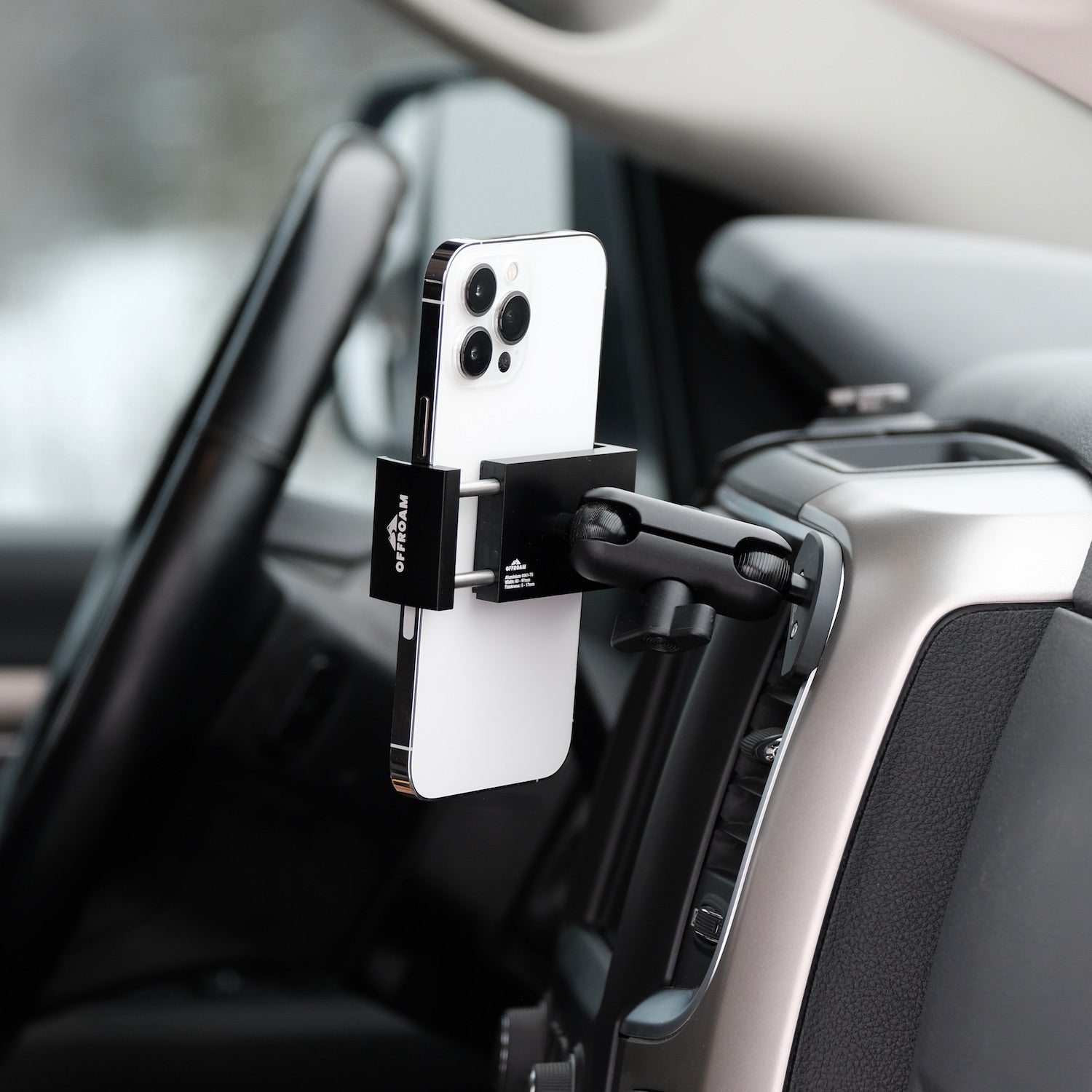 Image of Offroam Phone Mount installed securely in Ram 1500/2500/3500 2013-2018 | Ram Classic 2019-2024. This premium phone mount installs easily without drilling or glue. Spring loaded Universal holder for use with any phone. Perfect placement without blocking screens, driver view, or air flow. Fully adjustable positioning.