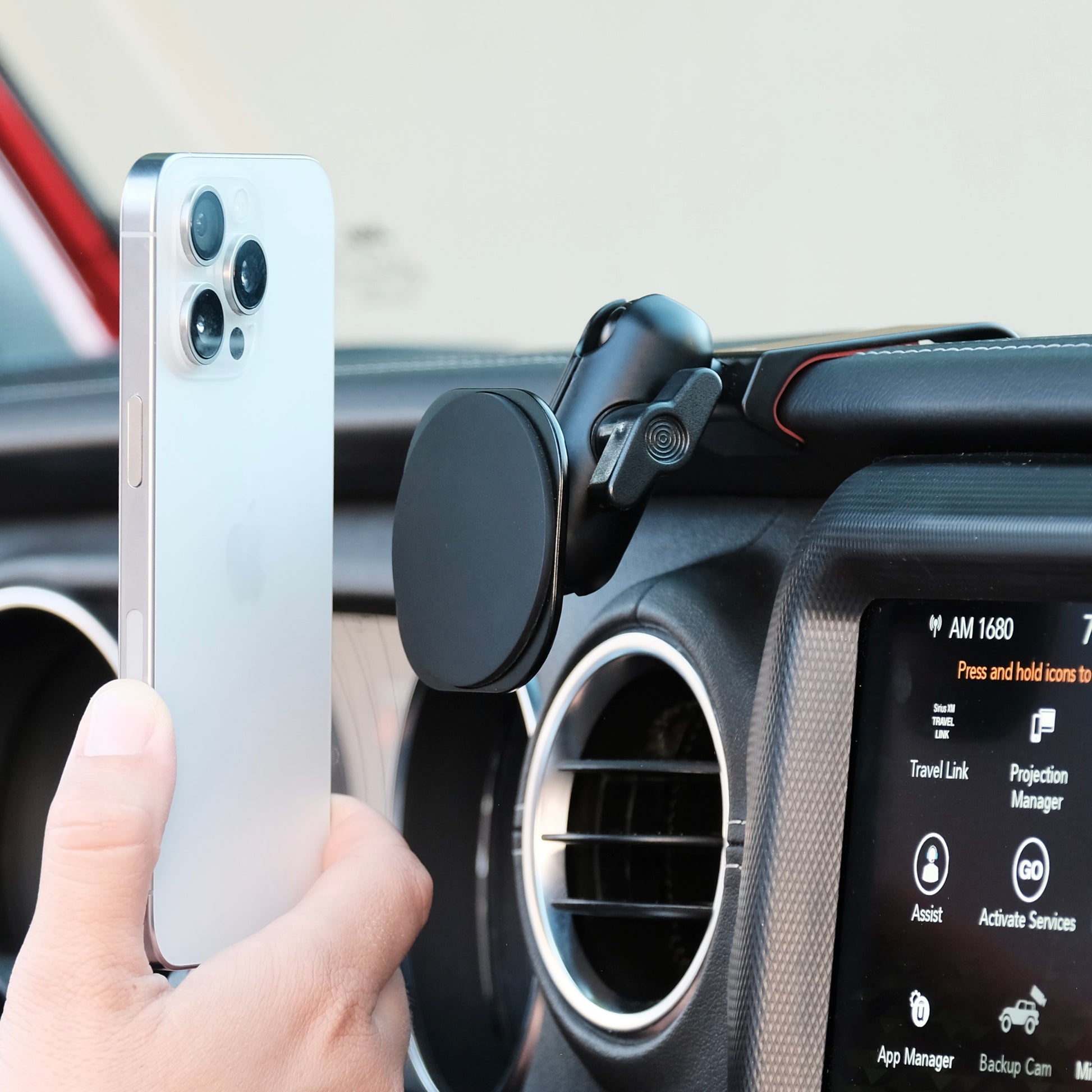 Image of Offroam MagSafe-compatible Phone Mount installed securely in Jeep Wrangler 2018-2023 | Gladiator 2019-2023. This premium phone mount installs easily without drilling or glue - it holds the phone below the dash keeping the windshield clear of obstructions. High force magnets hold phone on any trail, road, or track. Perfect placement without blocking screens, driver view, or air flow. Fully adjustable positioning.