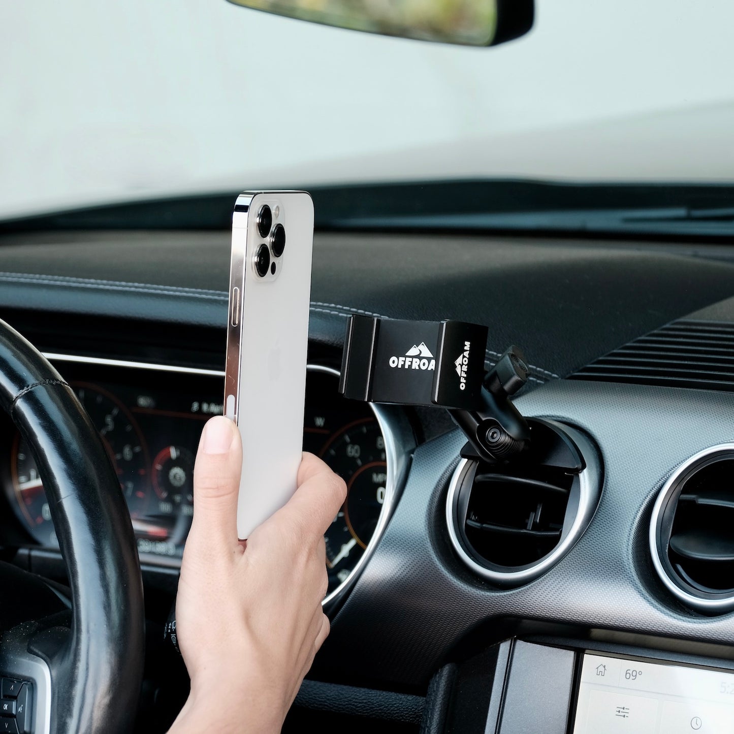 Image of Offroam Phone Mount installed securely in Ford Mustang 2015-2023. This premium phone mount installs easily without drilling or glue. Spring loaded Universal holder for use with any phone. Perfect placement without blocking screens, driver view, or air flow. Fully adjustable positioning.