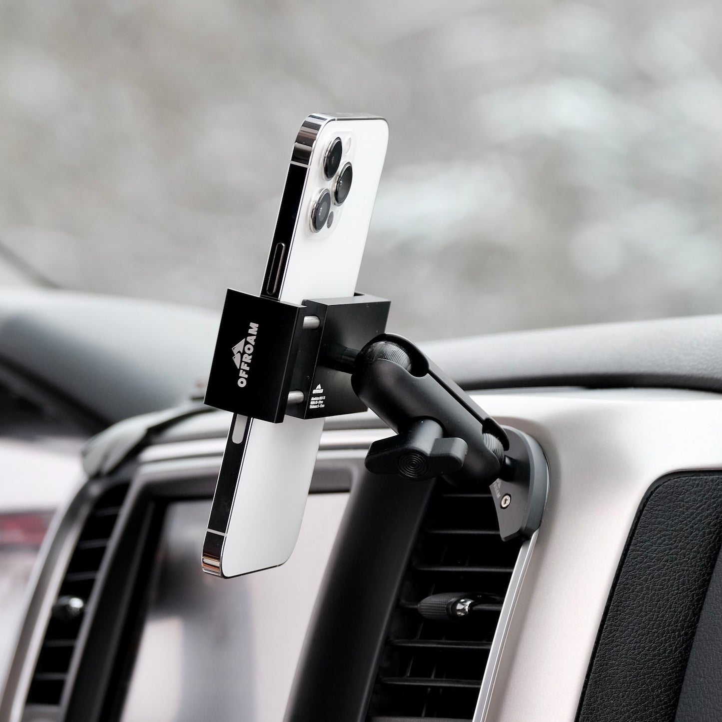 Image of Offroam Phone Mount installed securely in Ram 1500/2500/3500 2013-2018 | Ram Classic 2019-2024. This premium phone mount installs easily without drilling or glue. Spring loaded Universal holder for use with any phone. Perfect placement without blocking screens, driver view, or air flow. Fully adjustable positioning.