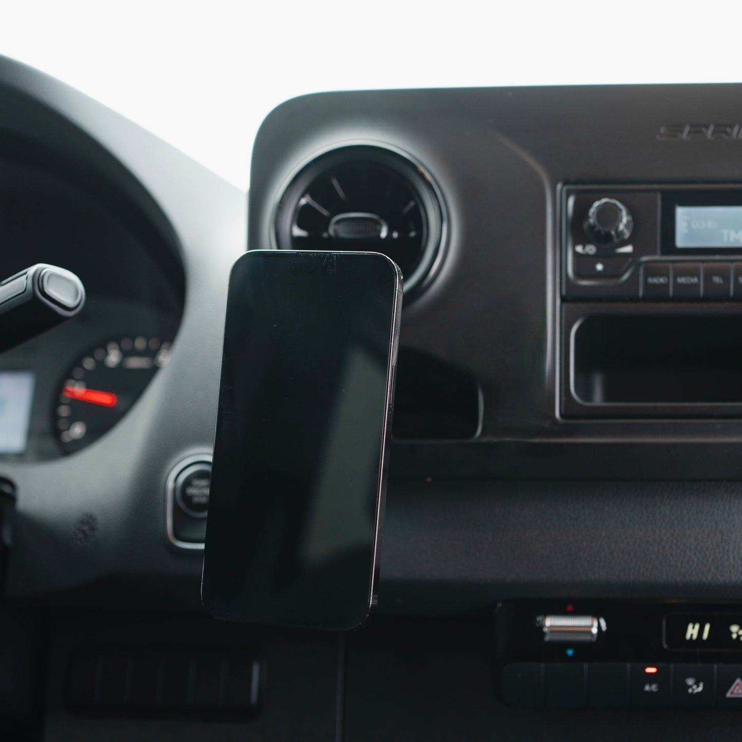 Image of Offroam MagSafe-compatible Phone Mount installed securely in Mercedes-Benz Sprinter 2019-2026. This premium phone mount installs easily without drilling or glue. High force magnets hold phone on any trail, road, or track. Perfect placement without blocking screens, driver view, or air flow. Fully adjustable positioning.