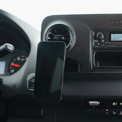 Image of Offroam MagSafe-compatible Phone Mount installed securely in Mercedes-Benz Sprinter 2019-2026. This premium phone mount installs easily without drilling or glue. High force magnets hold phone on any trail, road, or track. Perfect placement without blocking screens, driver view, or air flow. Fully adjustable positioning.